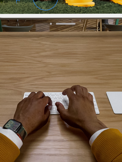Deux mains placées au-dessus d’un Magic Keyboard